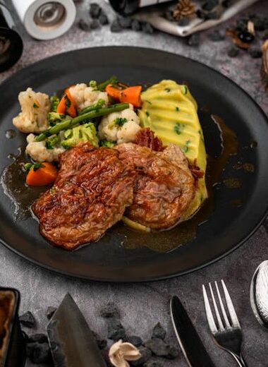 Savor a gourmet steak dinner with mashed potatoes and vegetables, ideal for food enthusiasts.